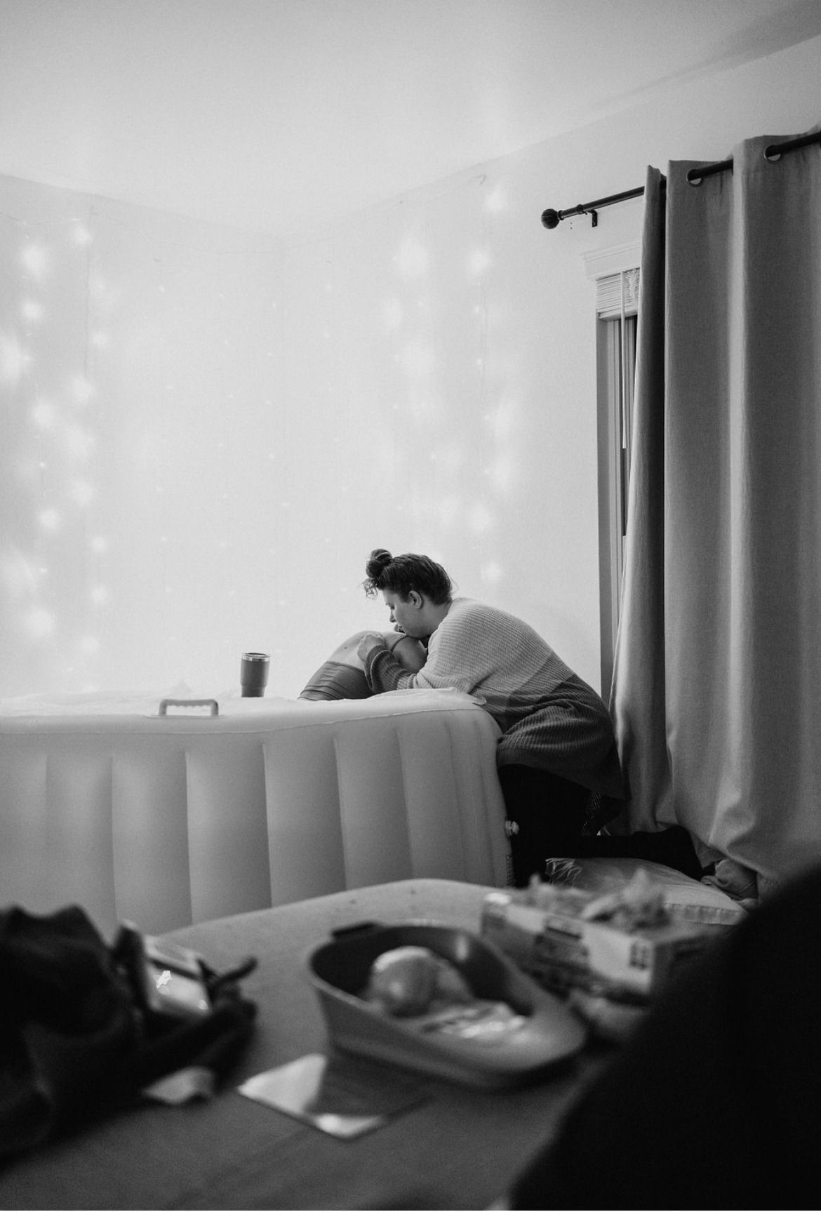 Doula supporting a laboring mother beside a birth pool