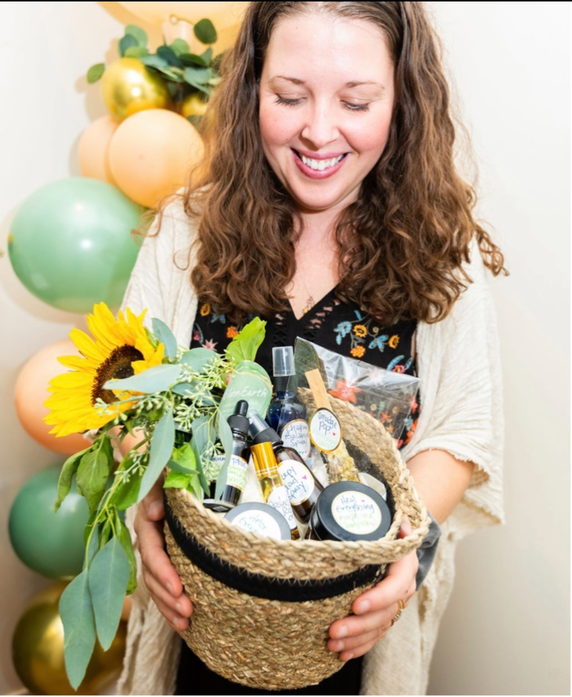 Bee holding a woven basket of handmade wellness products and flowers