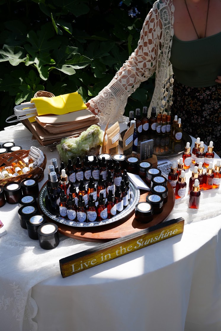 Handmade herbal apothecary products displayed at an outdoor market table